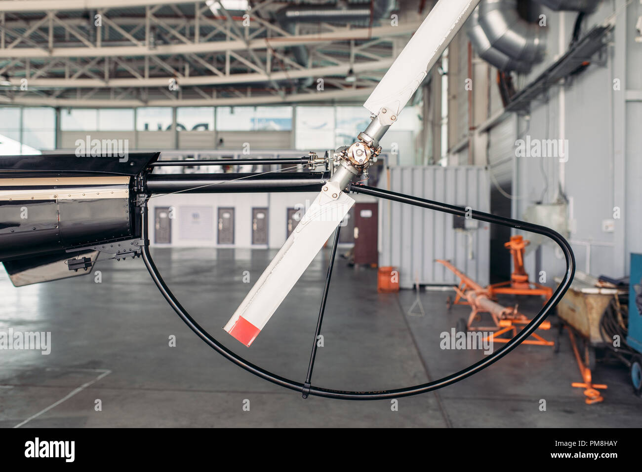 Il rotore di coda del piccolo elicottero closeup, vista laterale, nessuno. Torna elica di piccole copter, rotorblade del trinciapaglia, hangar interno sullo sfondo Foto Stock