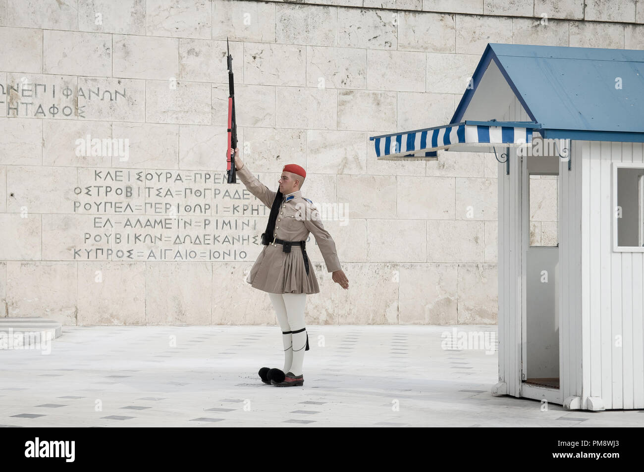 Una guardia visto al Milite Ignoto monumento davanti al parlamento greco. I turisti si vede guardando il cambio della guardia a Syndagma piazza davanti al parlamento greco ad Atene, in Grecia. Foto Stock