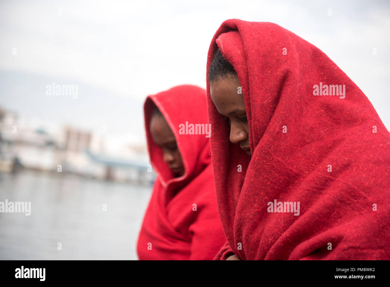 Due sub sahariana visto donne coperti con coperte di rosso dopo essere stato salvato. 79 migranti sono stati soccorsi in mare di Alboran dal Maritime Rescue Team dal Porto di Motril vicino a Granada. Foto Stock