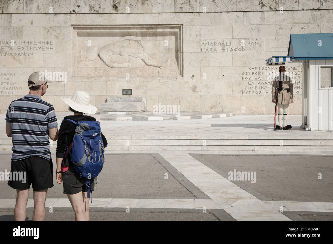 Due turisti visto guardando il soldato sconosciuto monumento. I turisti si vede guardando il cambio della guardia a Syndagma piazza davanti al parlamento greco ad Atene, in Grecia. Foto Stock