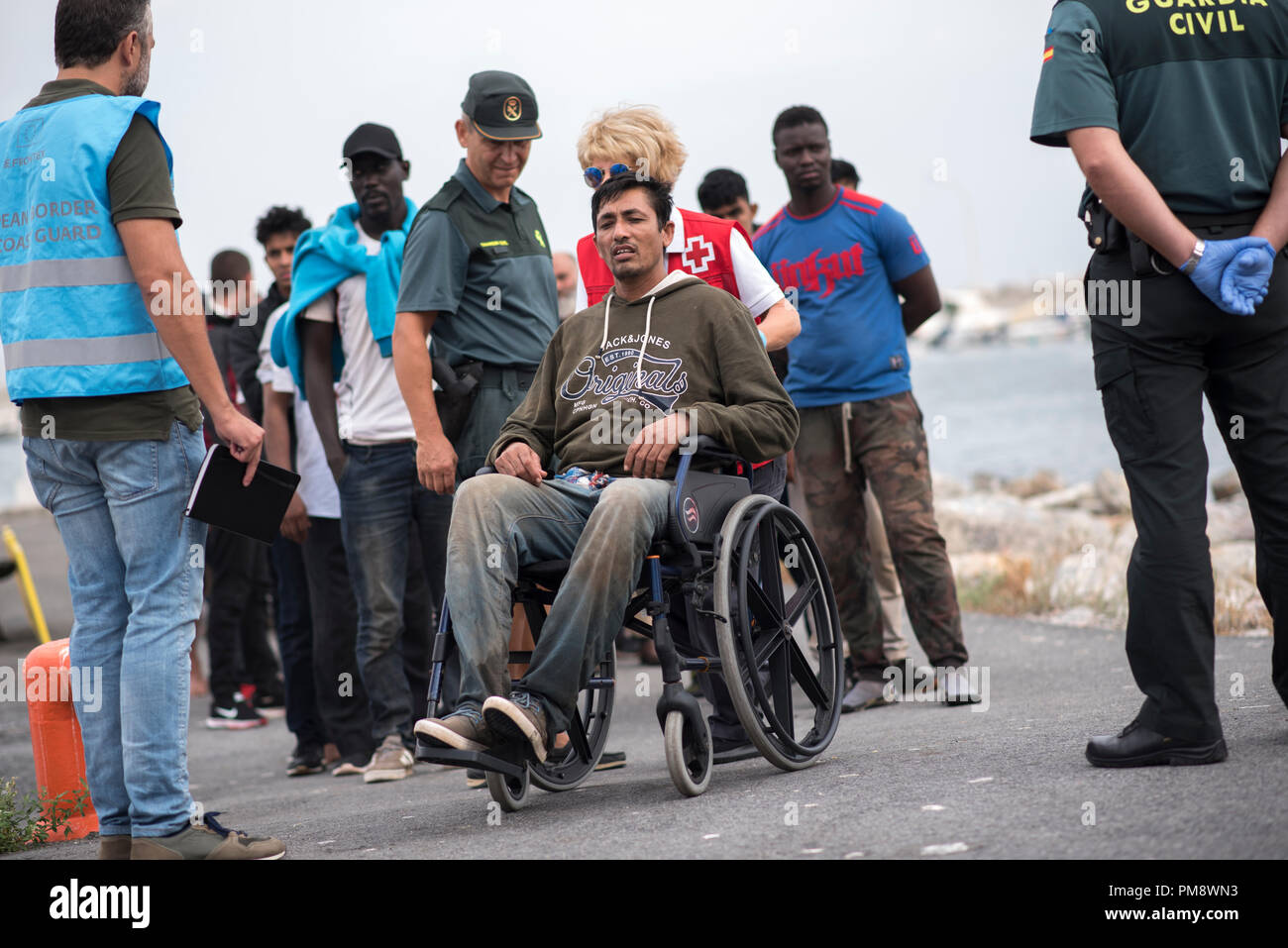 Un migrante dal Bangladesh è visto in una sedia a rotelle dopo essere stato salvato. 79 migranti sono stati soccorsi in mare di Alboran dal Maritime Rescue Team dal Porto di Motril vicino a Granada. Foto Stock