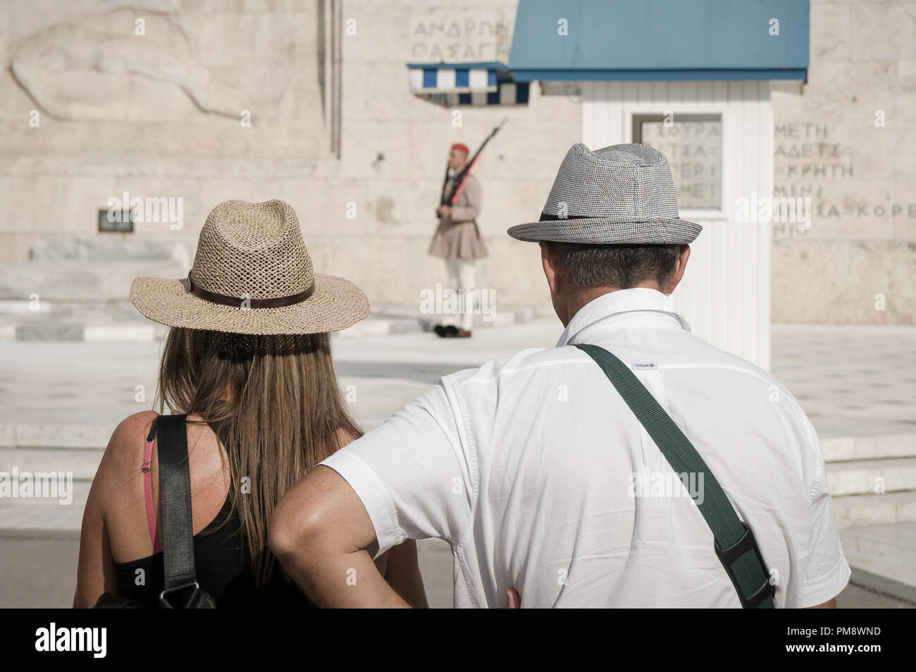 Due turisti visto guardando il cambio della guardia. I turisti si vede guardando il cambio della guardia a Syndagma piazza davanti al parlamento greco ad Atene, in Grecia. Foto Stock