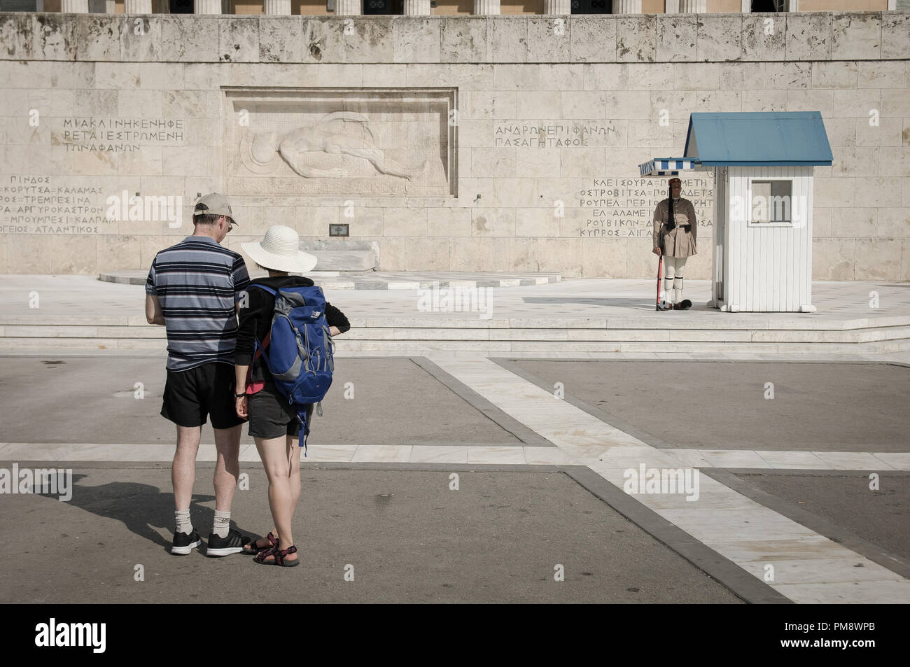 Due turisti visto guardando il soldato sconosciuto monumento. I turisti si vede guardando il cambio della guardia a Syndagma piazza davanti al parlamento greco ad Atene, in Grecia. Foto Stock