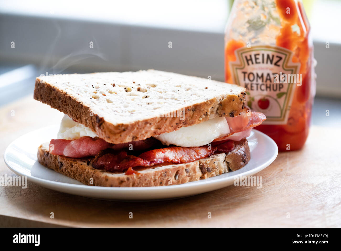 Un classico e tradizionale, deliziosa, inglese uova e bacon sandwich made con pane marrone Foto Stock