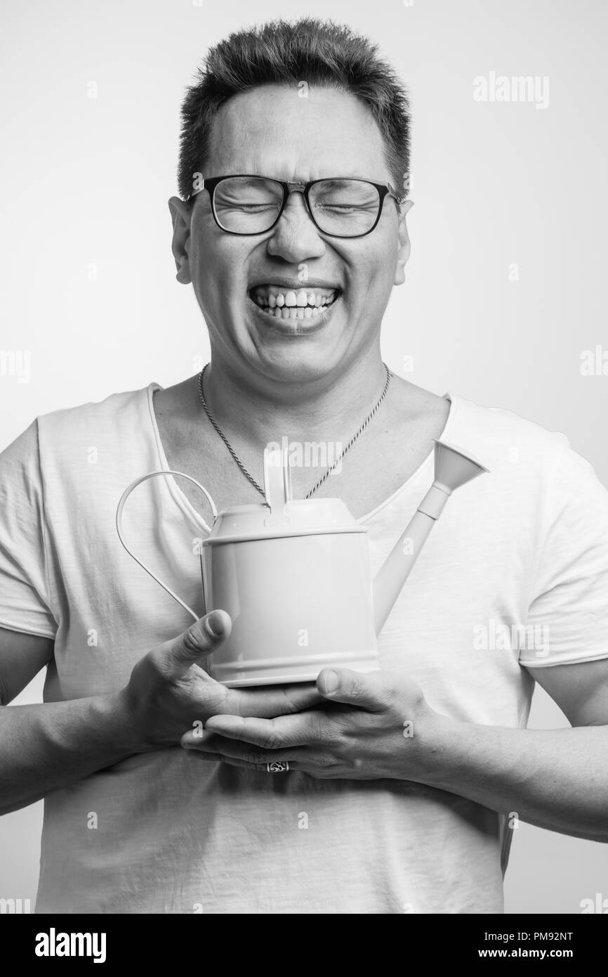 Happy funny uomo asiatico nel suo 30s in bianco al solito t-shirt con diverse emozioni positive Foto Stock