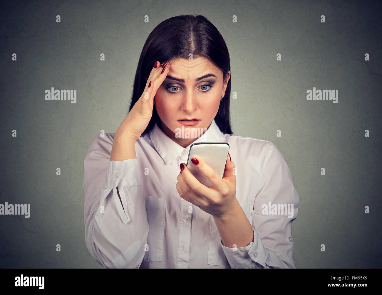 Sconvolto sconvolto grave donna guardando il suo telefono cellulare. Foto Stock