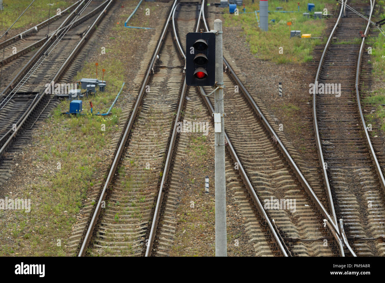 Il Semaforo si accende con una luce rossa sullo sfondo dei binari della ferrovia del Trasporto hub. Pattern. Vista dall'alto. Luce naturale Foto Stock