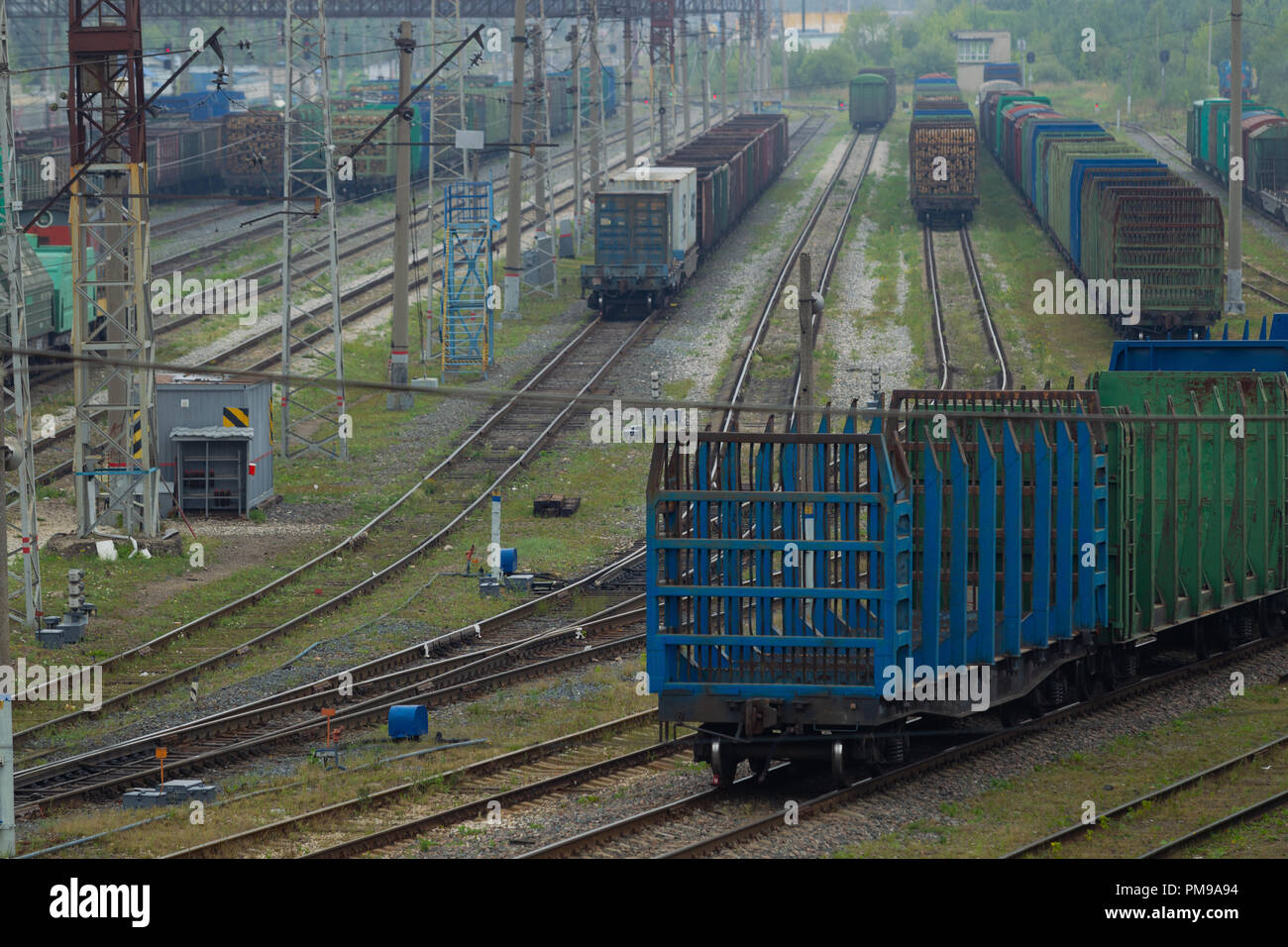 I treni merci, carri con carico stand sui binari della ferrovia del trasporto hub sullo sfondo del paesaggio industriale. Vista dall'alto. L naturale Foto Stock