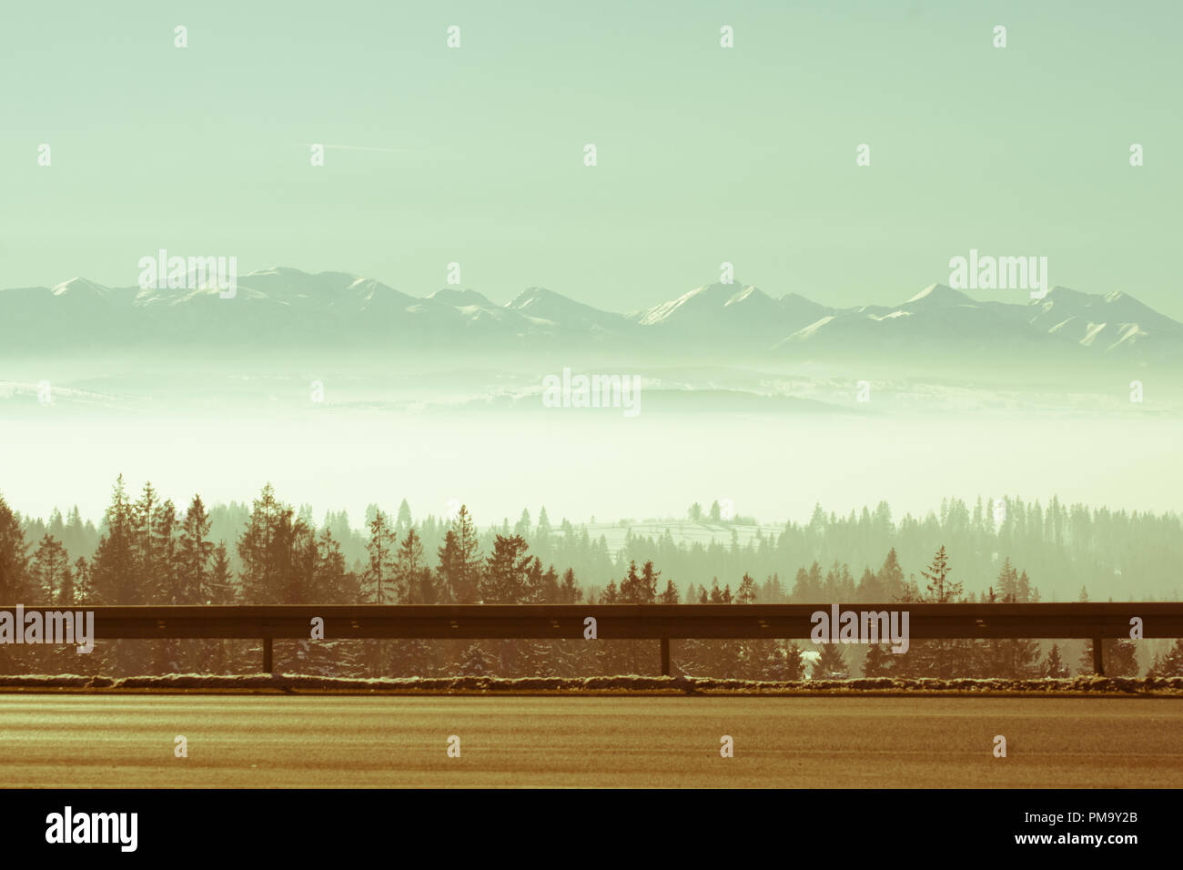 Paesaggio invernale di montagne, foreste e strada Foto Stock