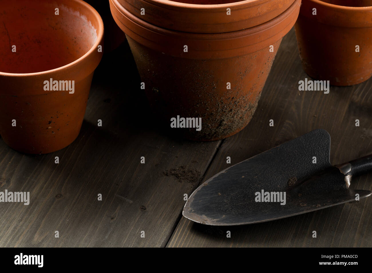 Gruppo di vuoto, utilizzato in terracotta pentole di piantagione sul tavolo di legno sfondo con utensile da giardinaggio e pala di giardinaggio Foto Stock