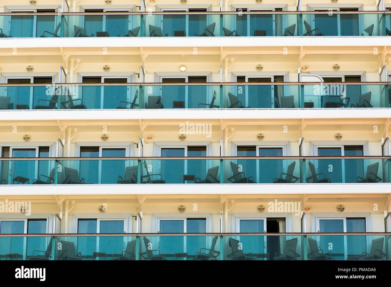 Righe di balconi e un terrazzo con tavoli e sedie per una vista esterna del mondo quando sei in vacanza Foto Stock