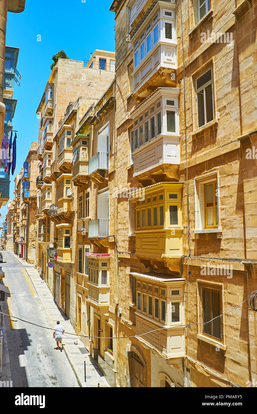 Il nativo di edifici di pietra calcarea con tradizionale maltese in legno balconi in san Domenico Street, Valletta, Malta. Foto Stock