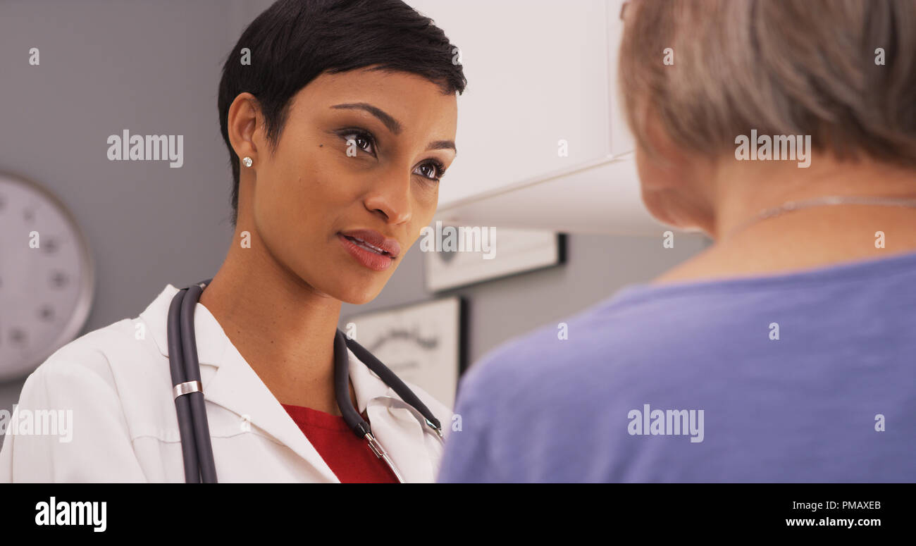 Giovani intelligenti medico donna parlare al paziente anziano Foto Stock