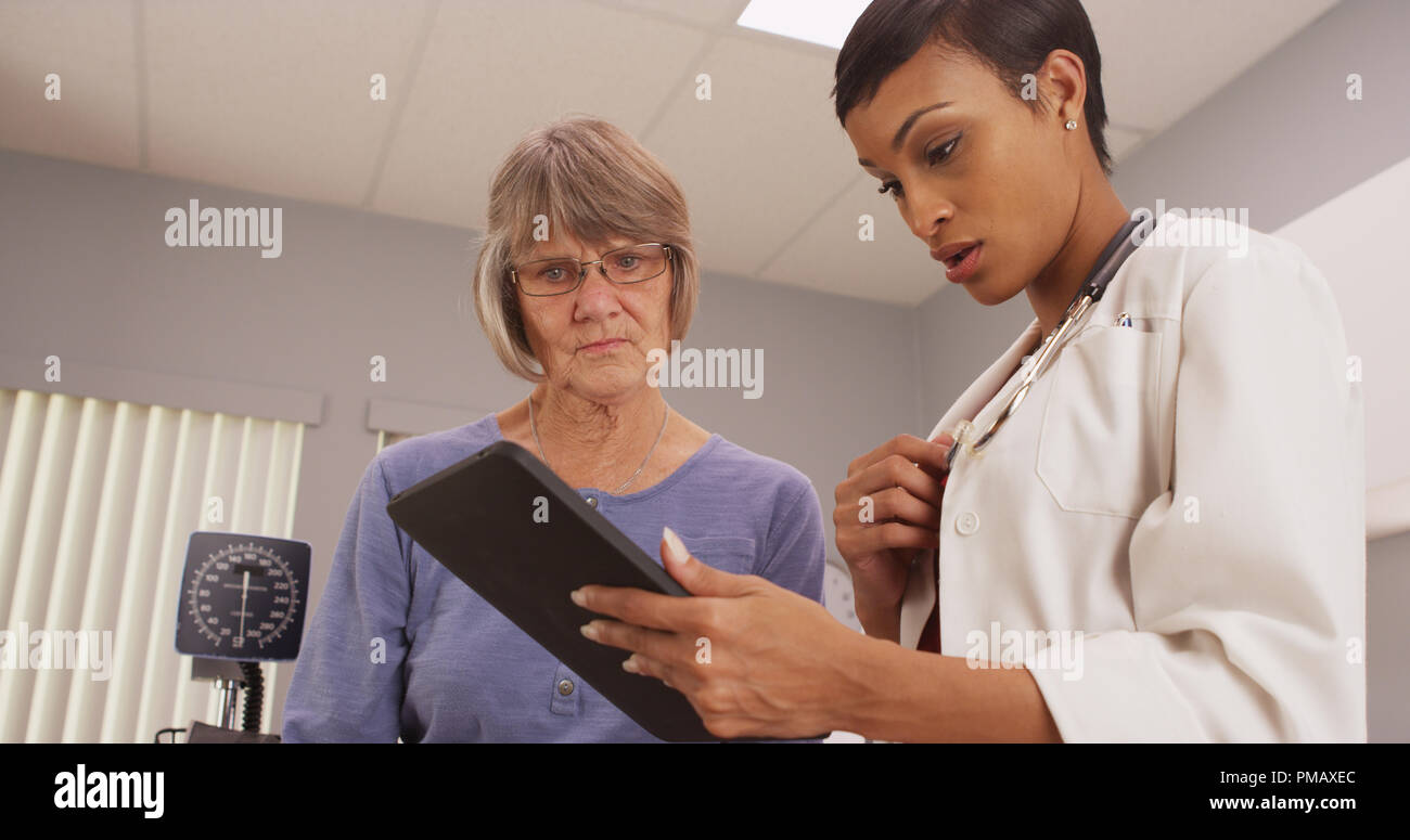 Giovani intelligenti medico guardando il tablet con paziente Foto Stock