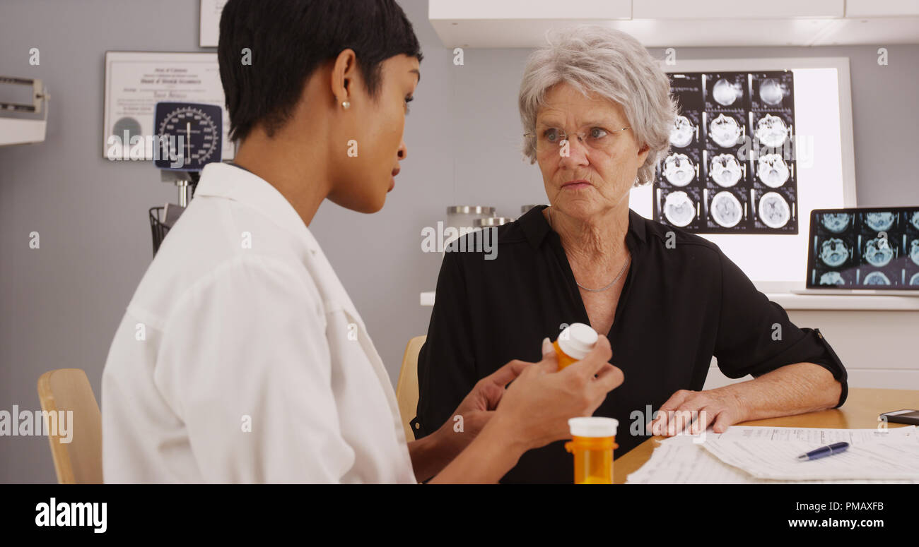 Giovane femmina intelligente medico di prescrivere il farmaco al paziente Foto Stock