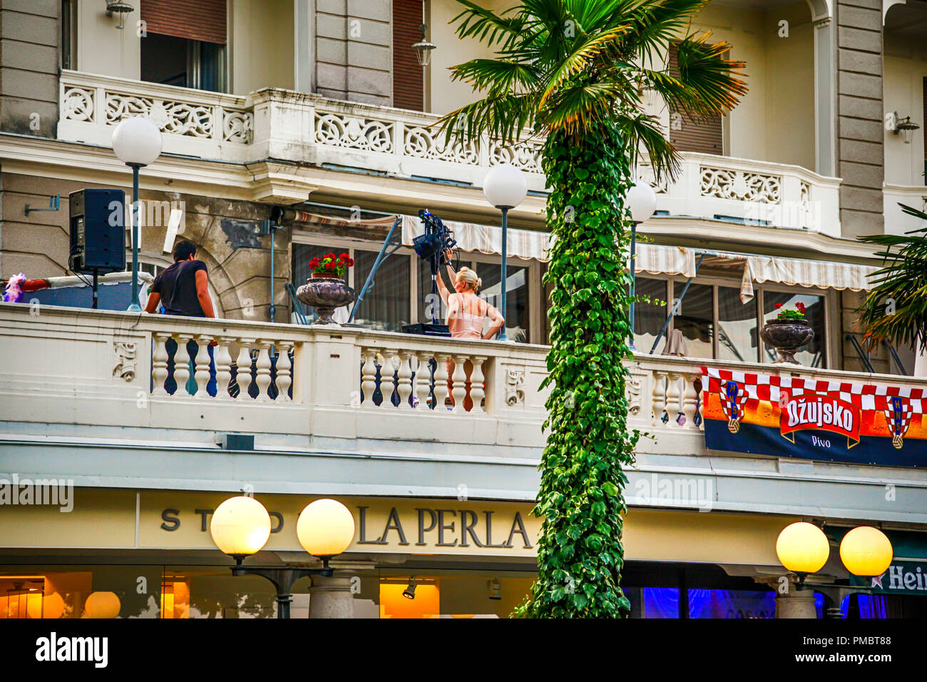 Il retro del Naomi Watts sul set cinematografico per il film 'Diana' sul balcone dell'Imperial Hotel a Opatija, Croazia circondata dalla troupe cinematografica Foto Stock