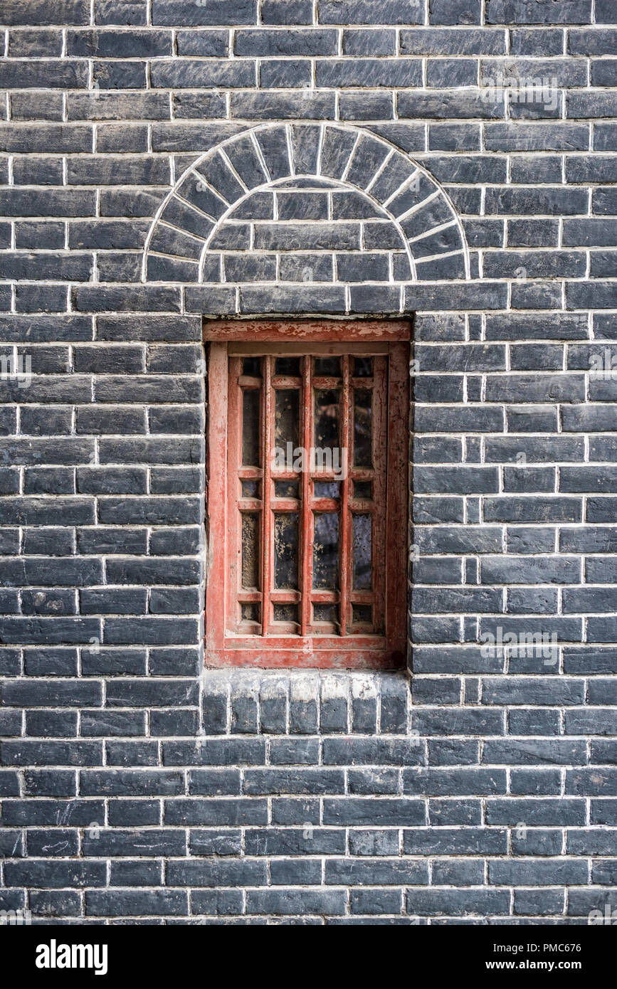 Piccola finestra rossa in un muro di mattoni, Chengdu Cina Foto Stock