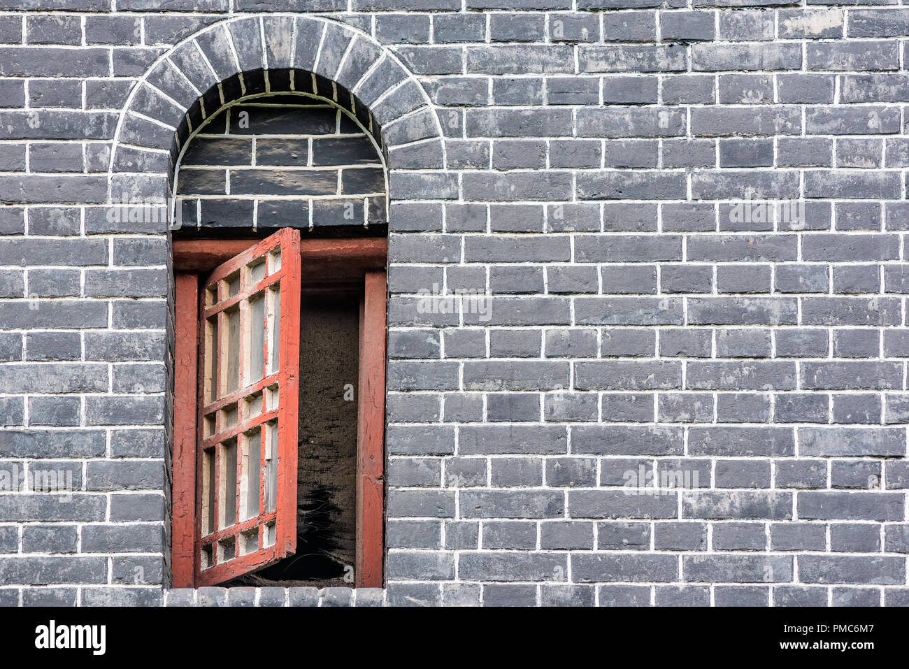 Piccola finestra rossa in un muro di mattoni, Chengdu Cina Foto Stock