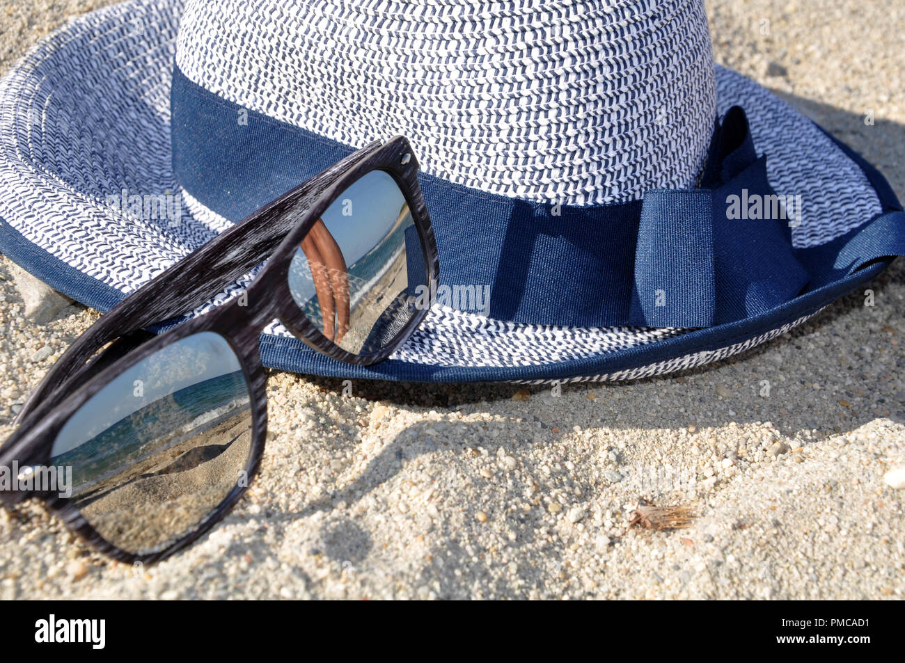 Occhiali da sole e un cappello sulla spiaggia Foto Stock