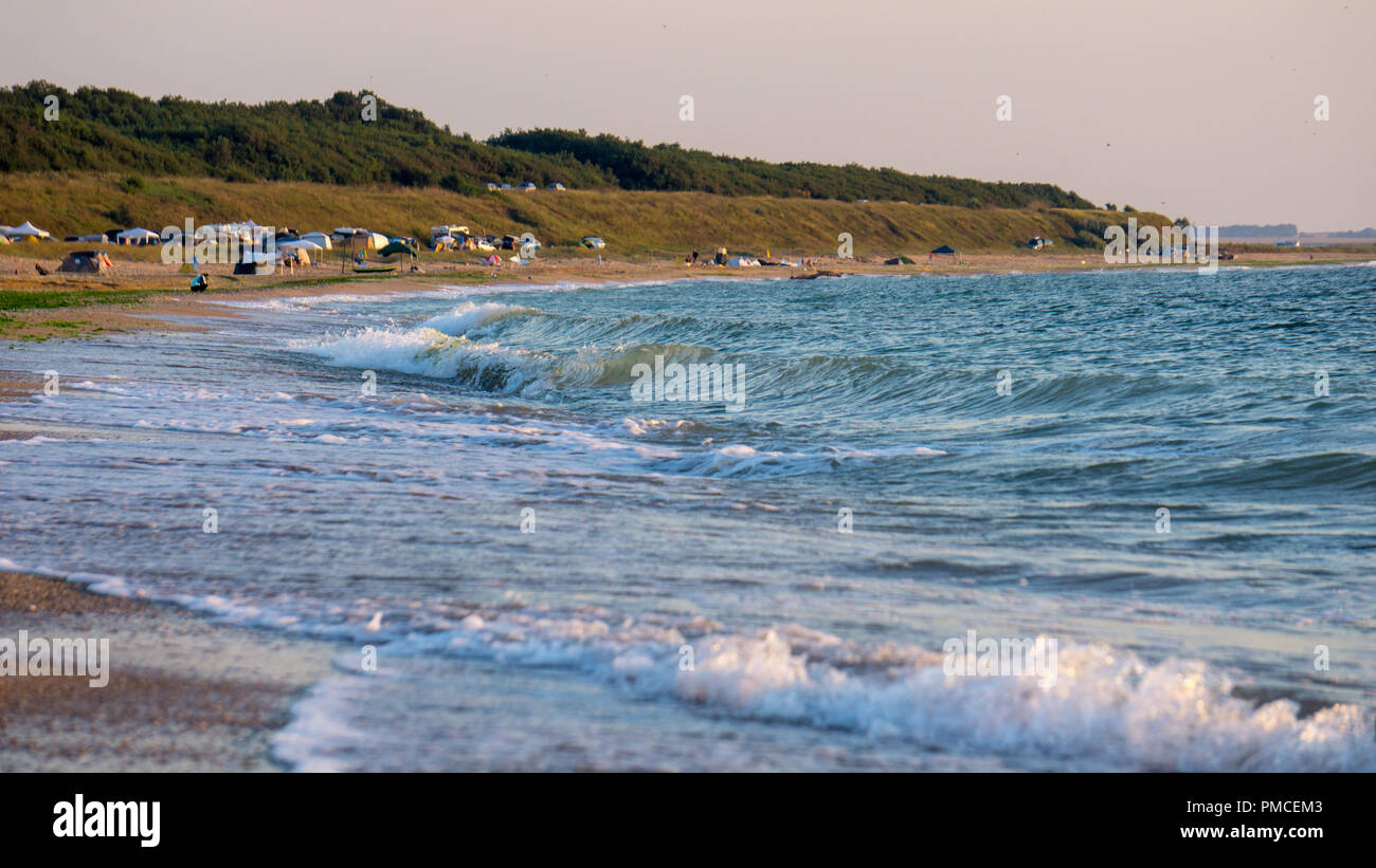 Piccolo e tranquillo delle forme d'onda colpendo la riva Foto Stock