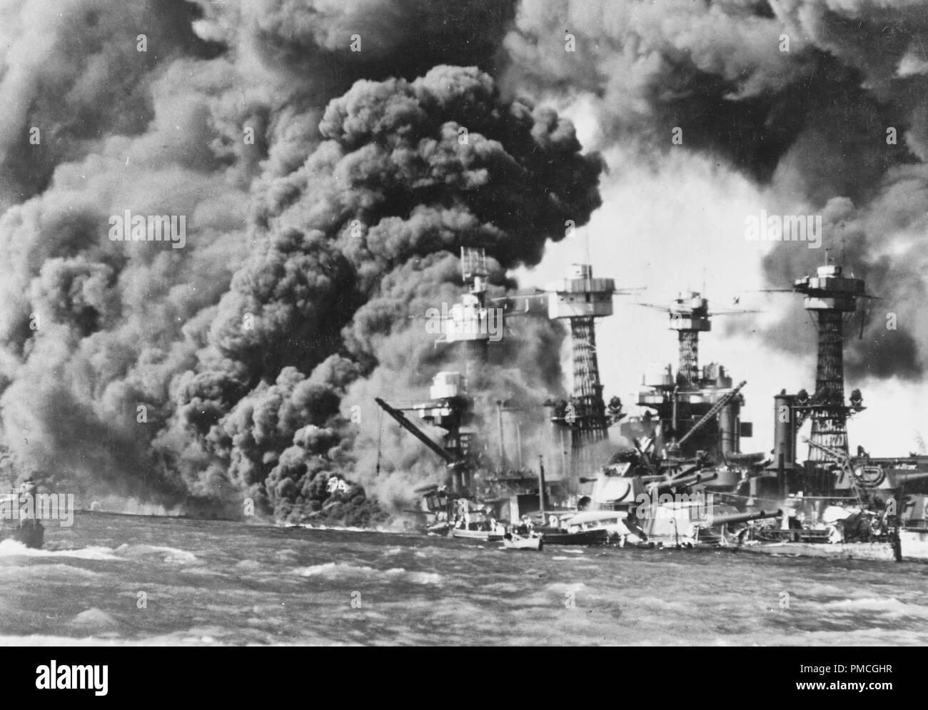 USS West Virginia (BB-48) ardente avanti, immediatamente dopo il giapponese attacco aereo. USS Tennessee (BB-43) è sulla Corazzata affondata il lato opposto. Attacco giapponese a Pearl Harbor, 7 Dicembre 1941 Foto Stock