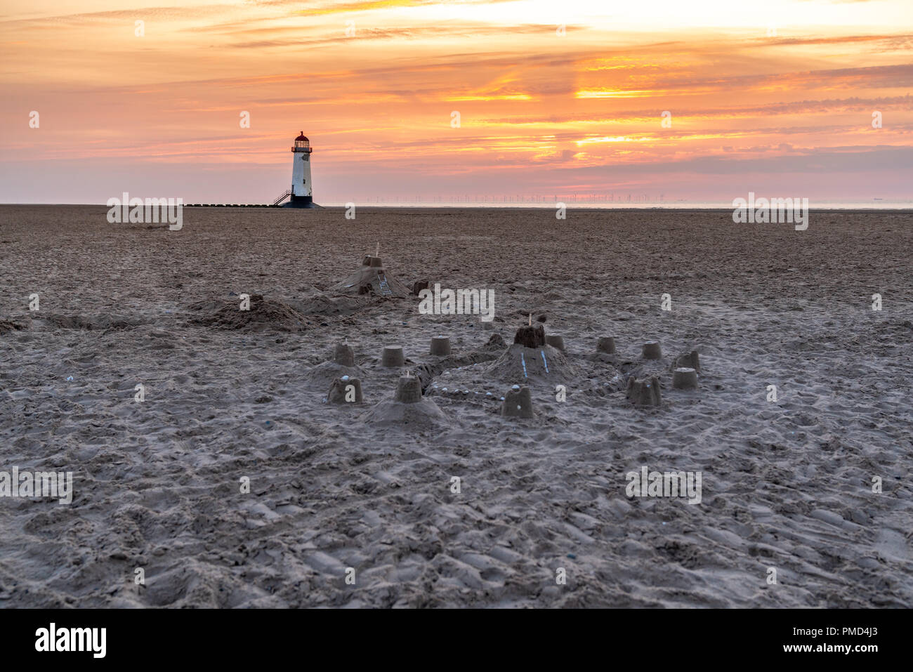 Il Sandcastles On la spiaggia, con serata nuvole e punto di Ayr il faro in background, vicino Talacre, Flintshire, Wales, Regno Unito Foto Stock