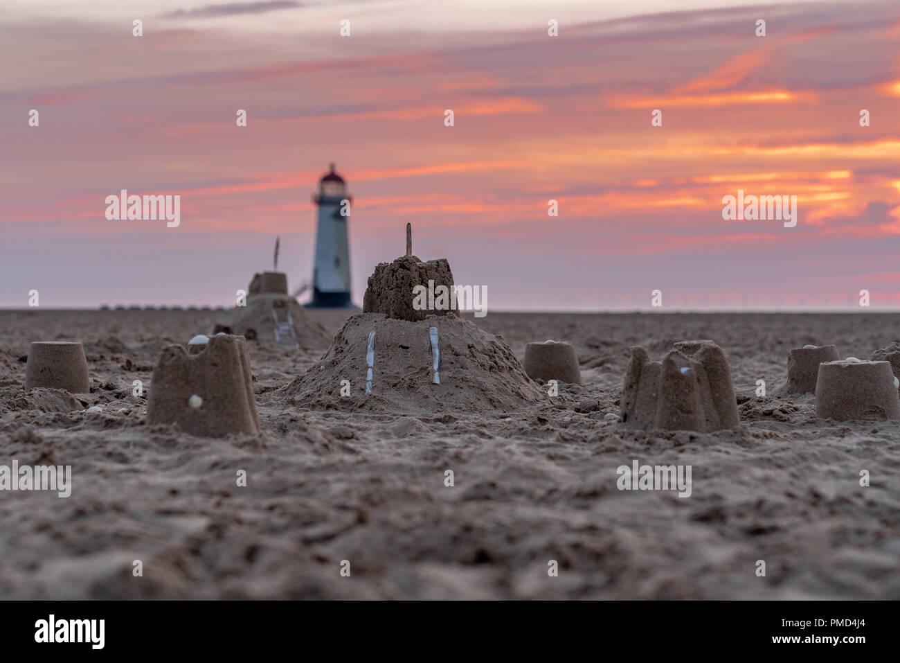 Il Sandcastles On la spiaggia, con serata nuvole e punto di Ayr il faro in background, vicino Talacre, Flintshire, Wales, Regno Unito Foto Stock