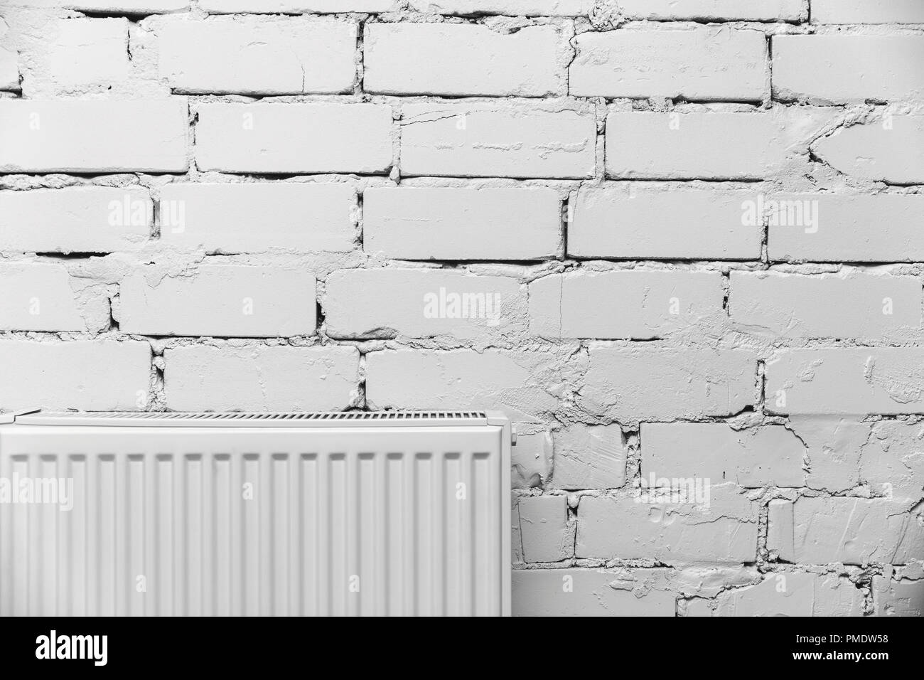 Bianco parete in mattoni con radiatore Foto Stock