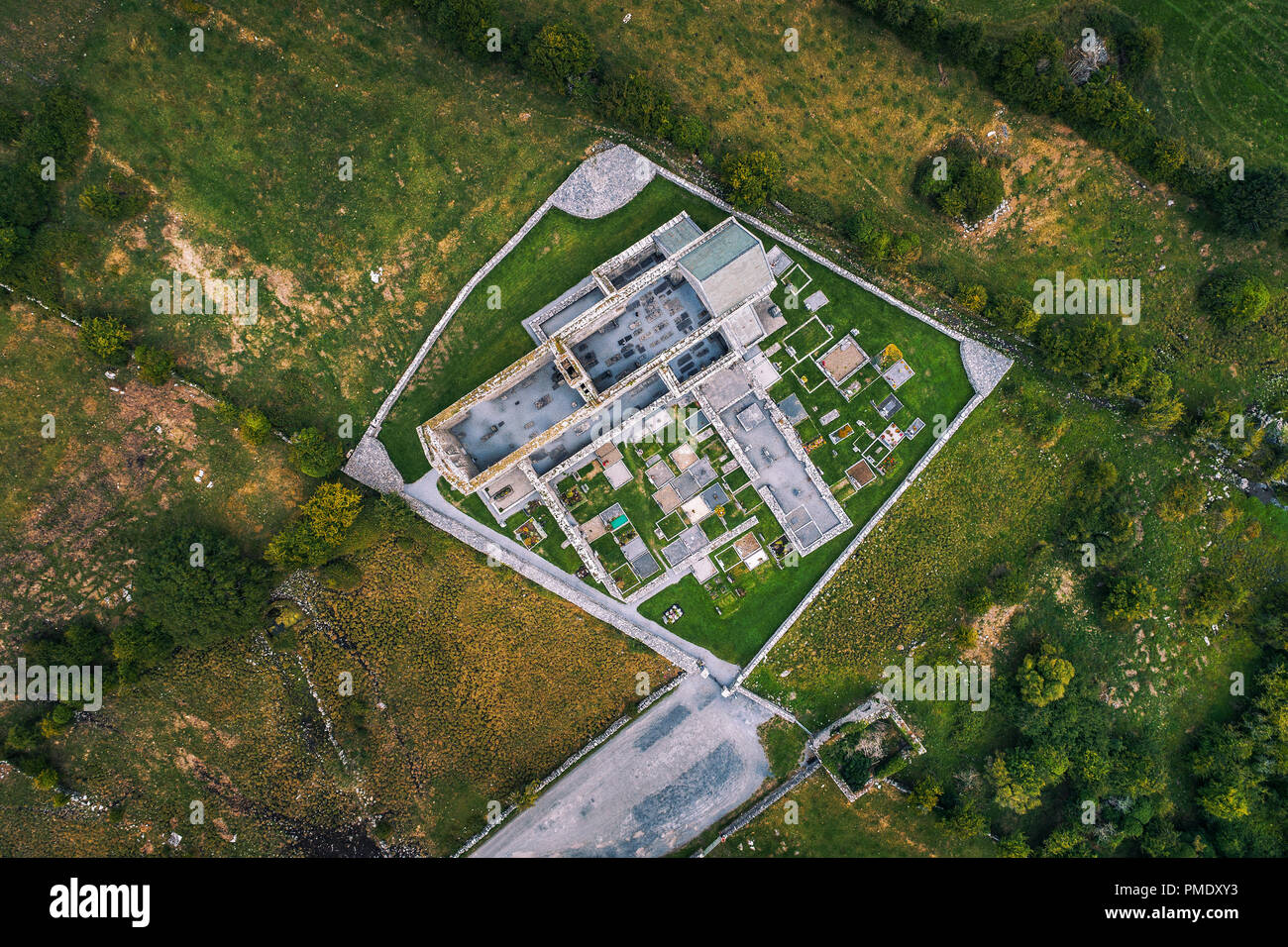 Corcomroe Abbey rovine e il suo cimitero situato nel Burren regione della contea di Clare, Irlanda. Vista aerea da un drone guardando verso il basso. Foto Stock