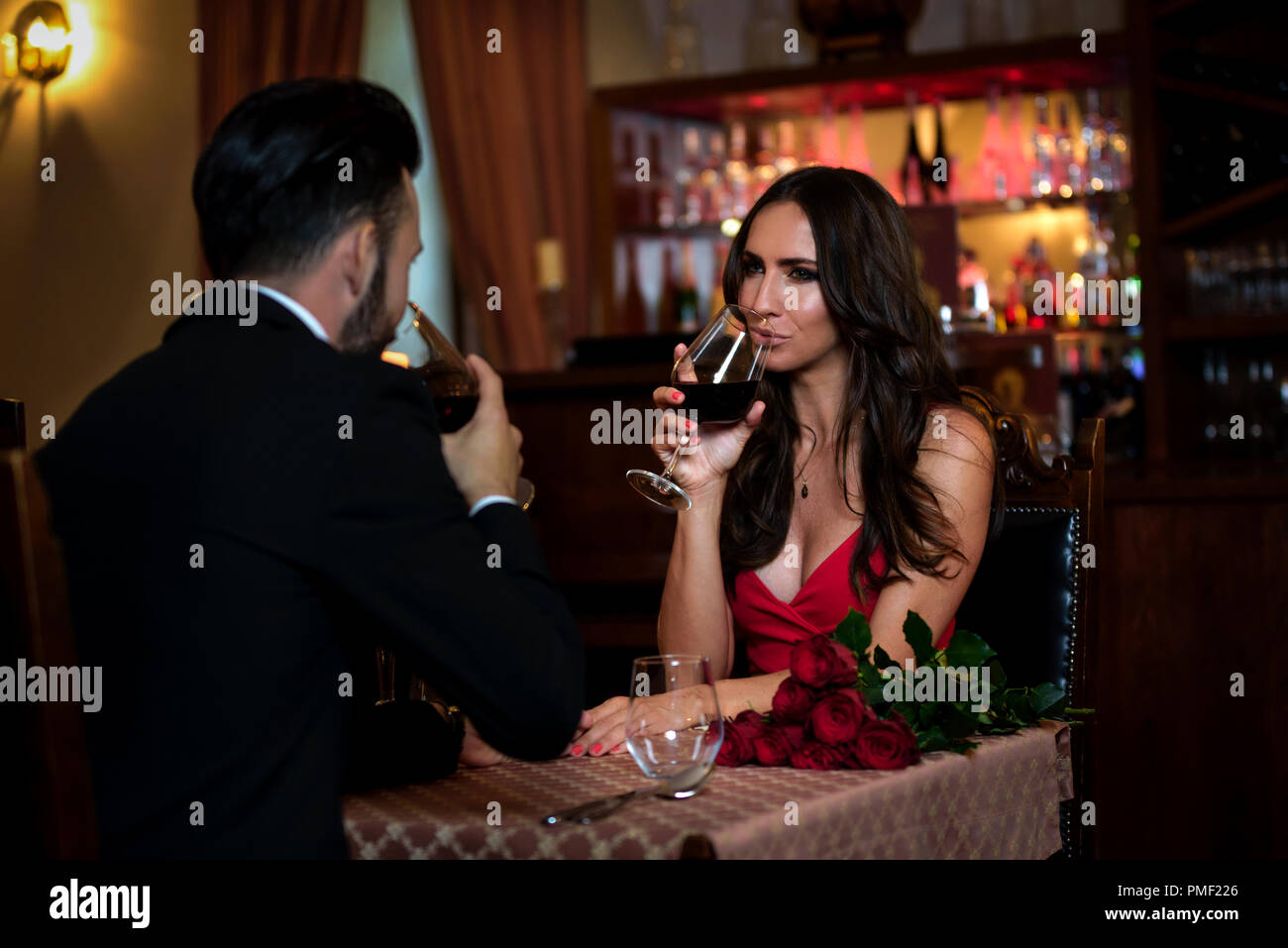Coppia attraente in amore è la datazione e bere vino durante una cena romantica nel ristorante. Foto Stock