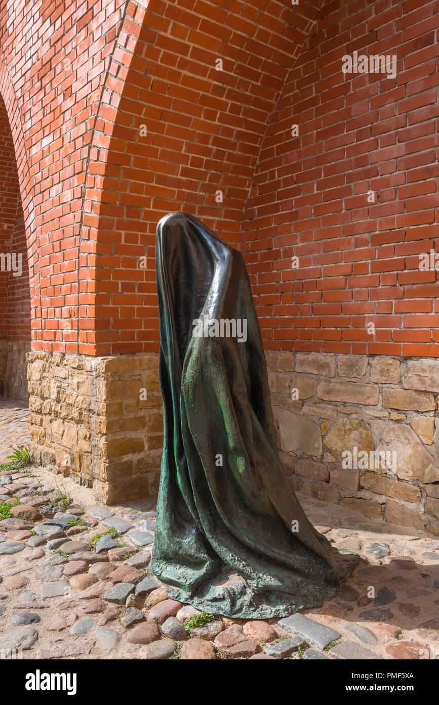 Una scultura moderna installazione dal titolo Il fantasma situata sotto un arco nella cinta muraria medievale della città vecchia di Riga, Lettonia. Foto Stock