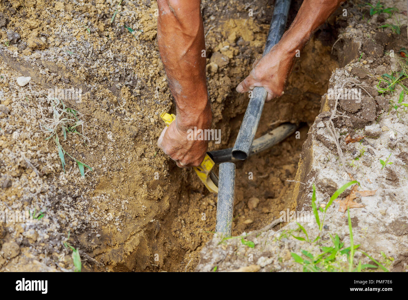 Uomo al lavoro installazione di irrigazione a goccia impianto con tubazioni in massa Foto Stock