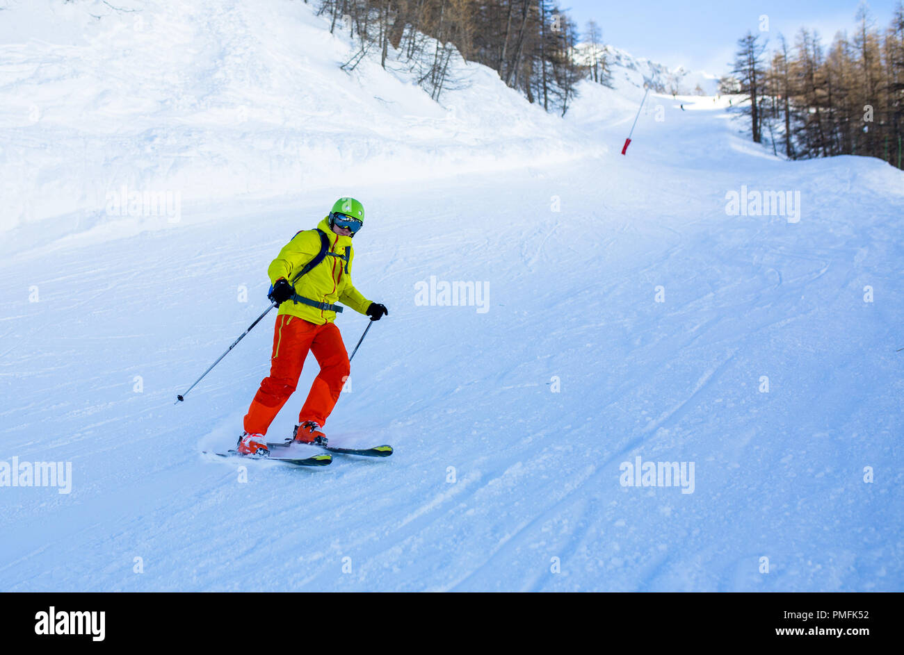 Immagine dell uomo di sport sciare sul pendio nevoso durante il giorno Foto Stock