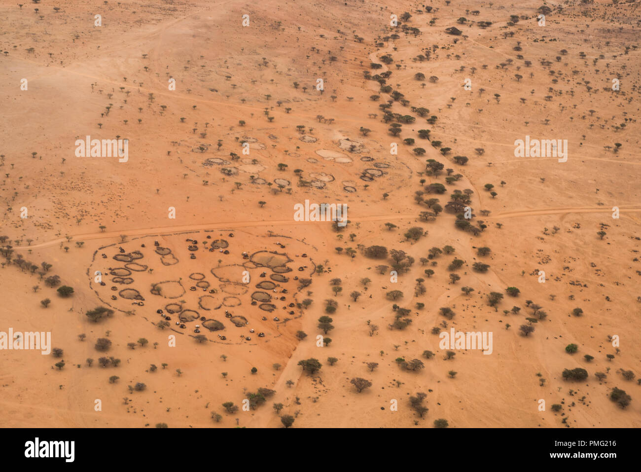 Un top-down, vista aerea di una circolare tradizionale villaggio di capanne e involucri di origine animale accanto al letto secco di un fiume in arido deserto Kaisut vicino Marsabi Foto Stock