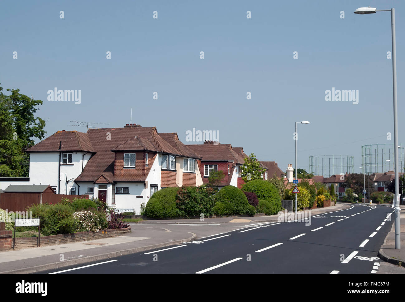 1930s chalet case in stile in motspur park accanto a una strada principale con dipinta di fresco iscrizioni Foto Stock