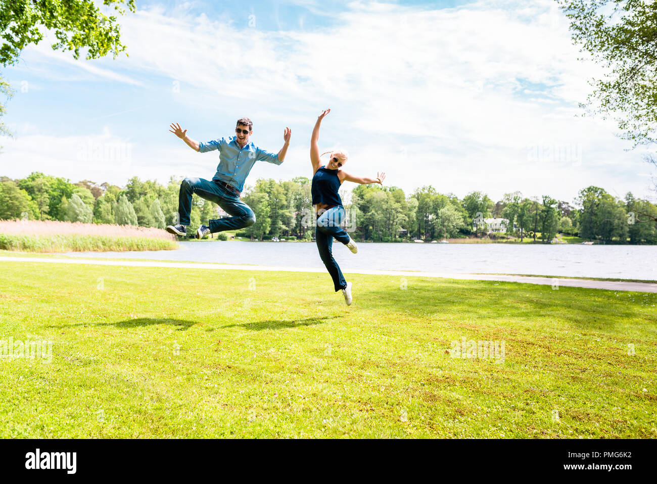 Emozionato coppia giovane jumping Foto Stock