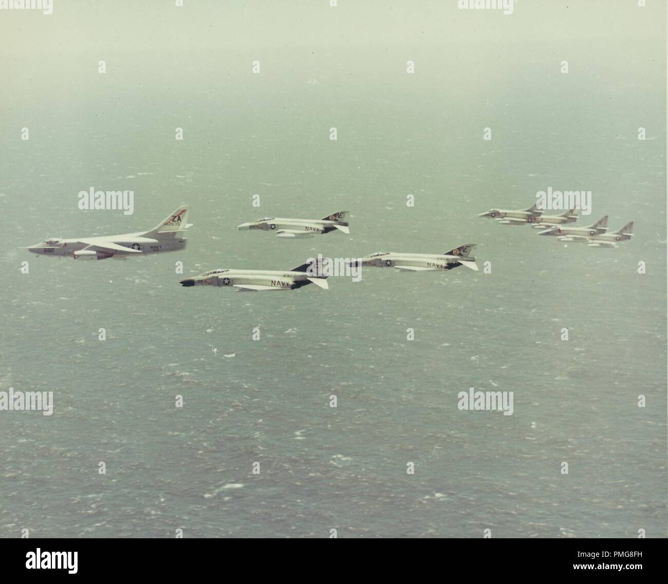 In bianco e nero la fotografia aerea mostra una squadra di 8 marina degli Stati Uniti, McDonnell Douglas F-4 Phantom II di aerei sorvolano open water, fotografato durante la Guerra del Vietnam, 1965. () Foto Stock