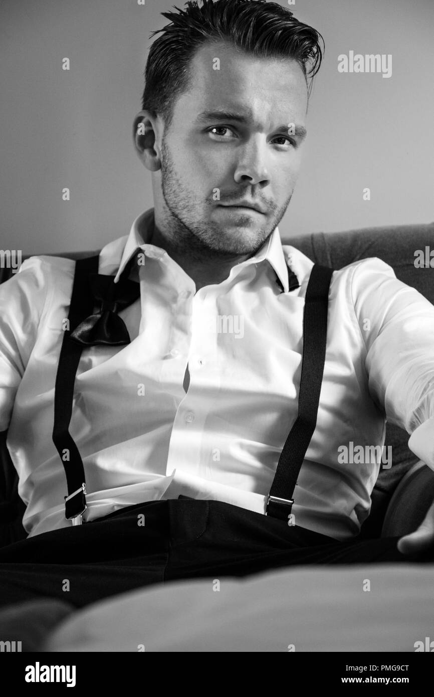 Uomo bello in hotel room, indossando smoking imprenditore con cravatta a farfalla allentati Foto Stock