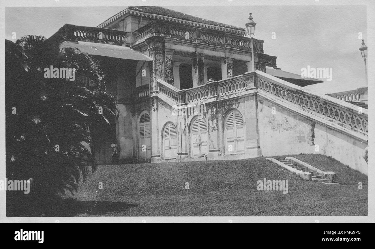 Fotografia in bianco e nero su cartoncino, con un'immagine di una sontuosa, di pietra o di un edificio in calcestruzzo, possibilmente una casa privata, girato da un angolo basso in vista in tre quarti, con arcate di porte in legno a livello del suolo, una grande scala che conduce al piano primo, pilastri di un open, anteriore zona portico, e di un ampia veranda sul tetto, probabile raccolti come un souvenir turistici durante un viaggio in Asia Del sud (probabile India), 1910. () Foto Stock