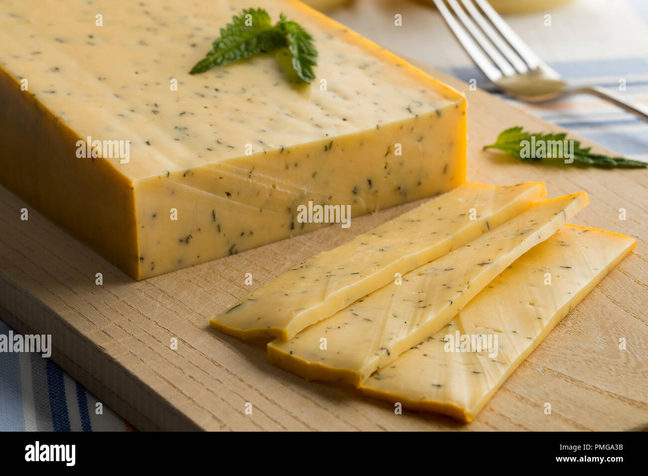 Pezzo di Gouda olandese ortica formaggio e fette Foto Stock