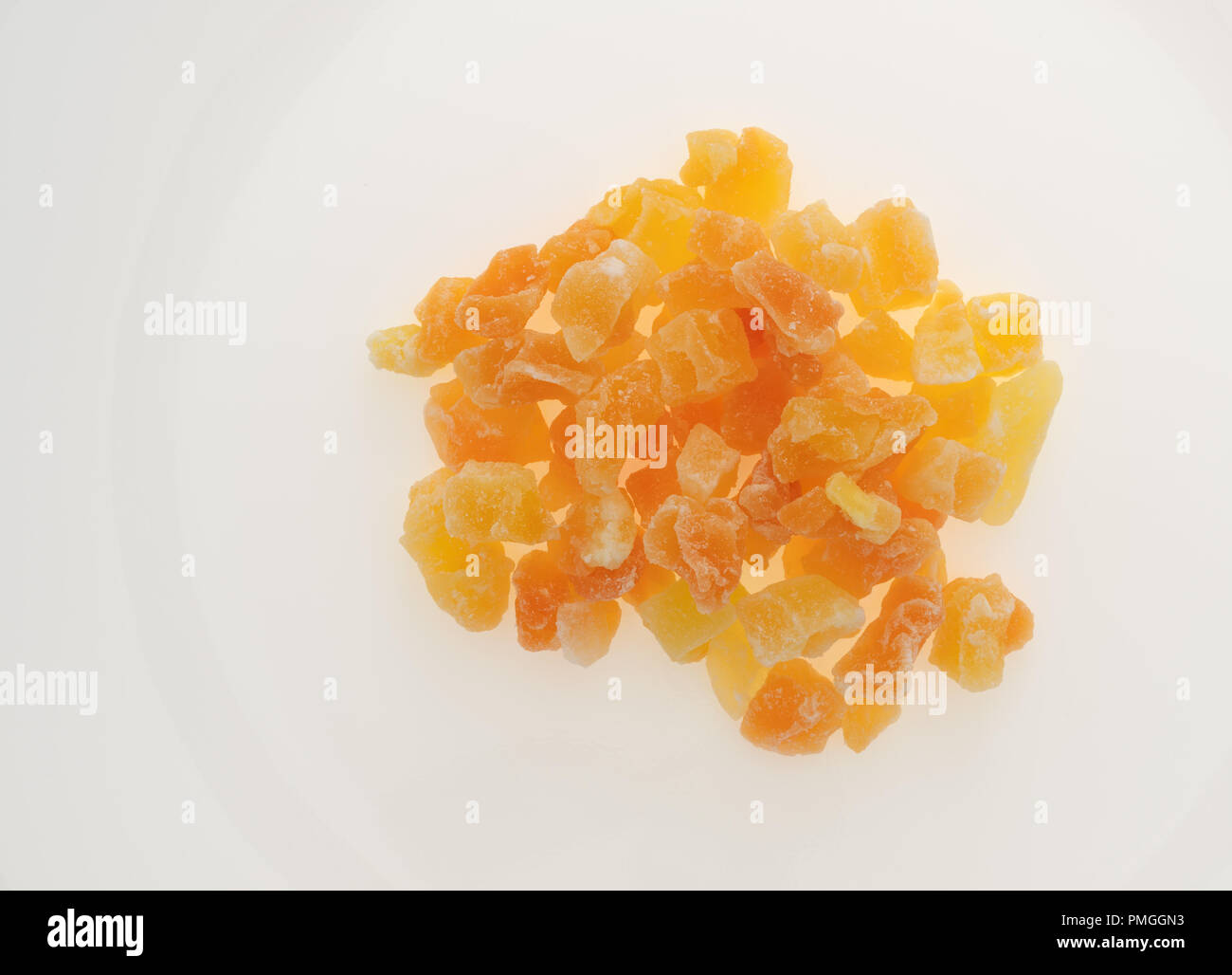 Vista dall'alto di una porzione di essiccati tagliati a dadini di melone su una piastra bianca. Foto Stock