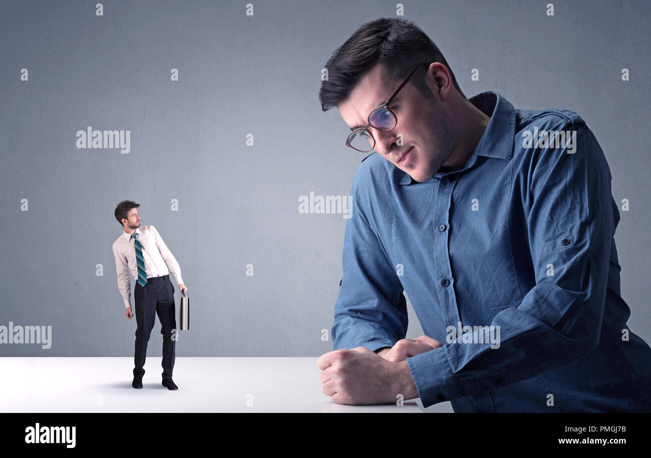 Giovane imprenditore professionale essendo arrabbiato con un altro imprenditore in miniatura Foto Stock
