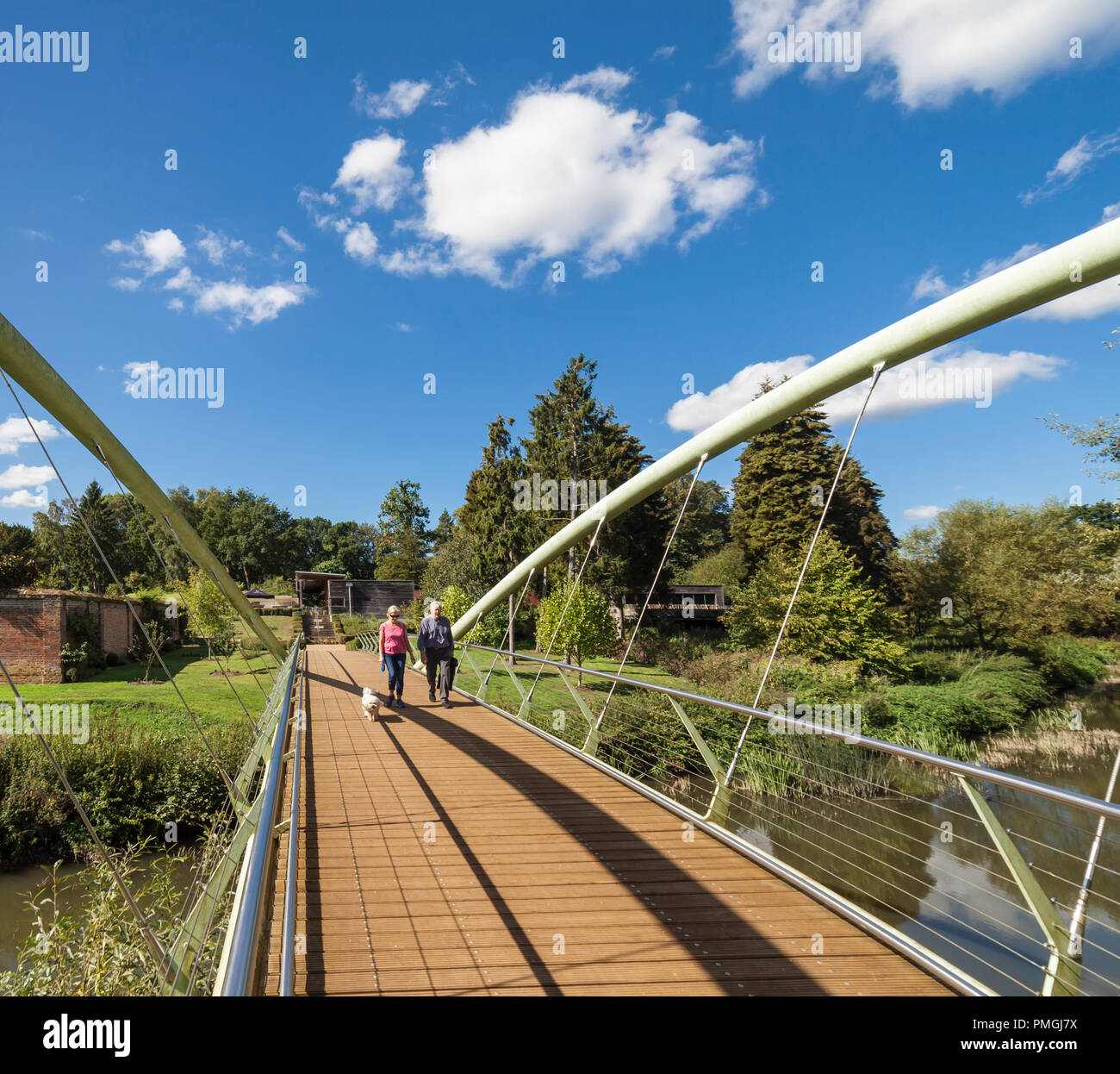Un ponte pedonale che attraversa il fiume mole che portano a Painshill Park. Foto Stock
