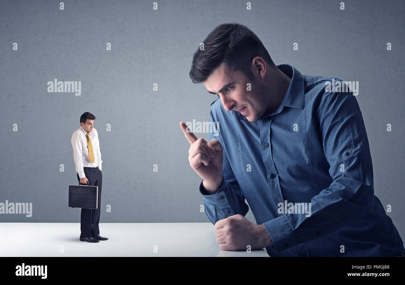 Giovane imprenditore professionale essendo arrabbiato con un altro imprenditore in miniatura Foto Stock