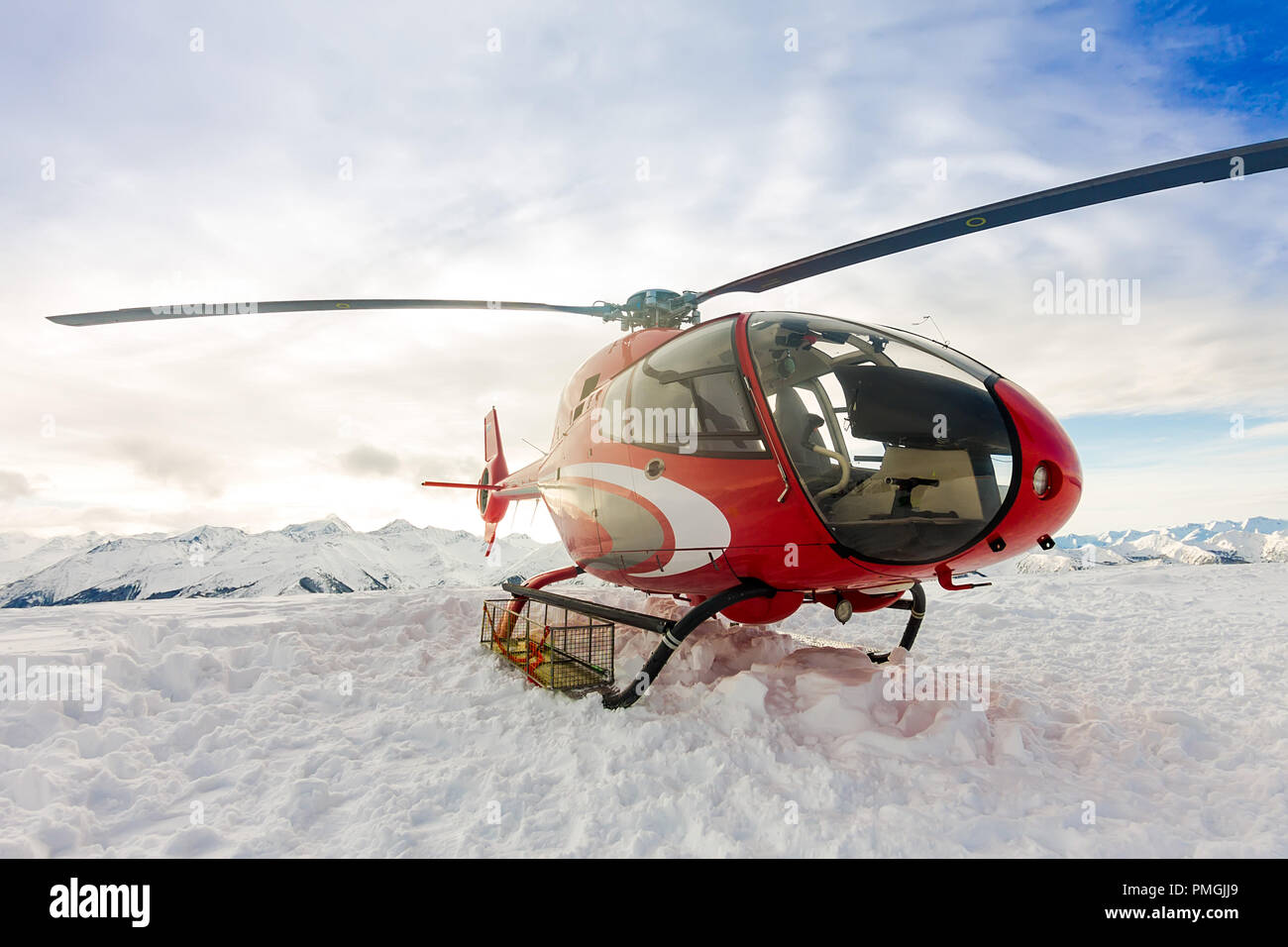 Red Salvataggio in elicottero atterra in piedi in montagne innevate. Foto Stock