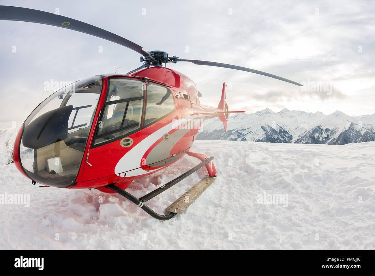 Red Salvataggio in elicottero atterra in piedi in montagne innevate. Foto Stock