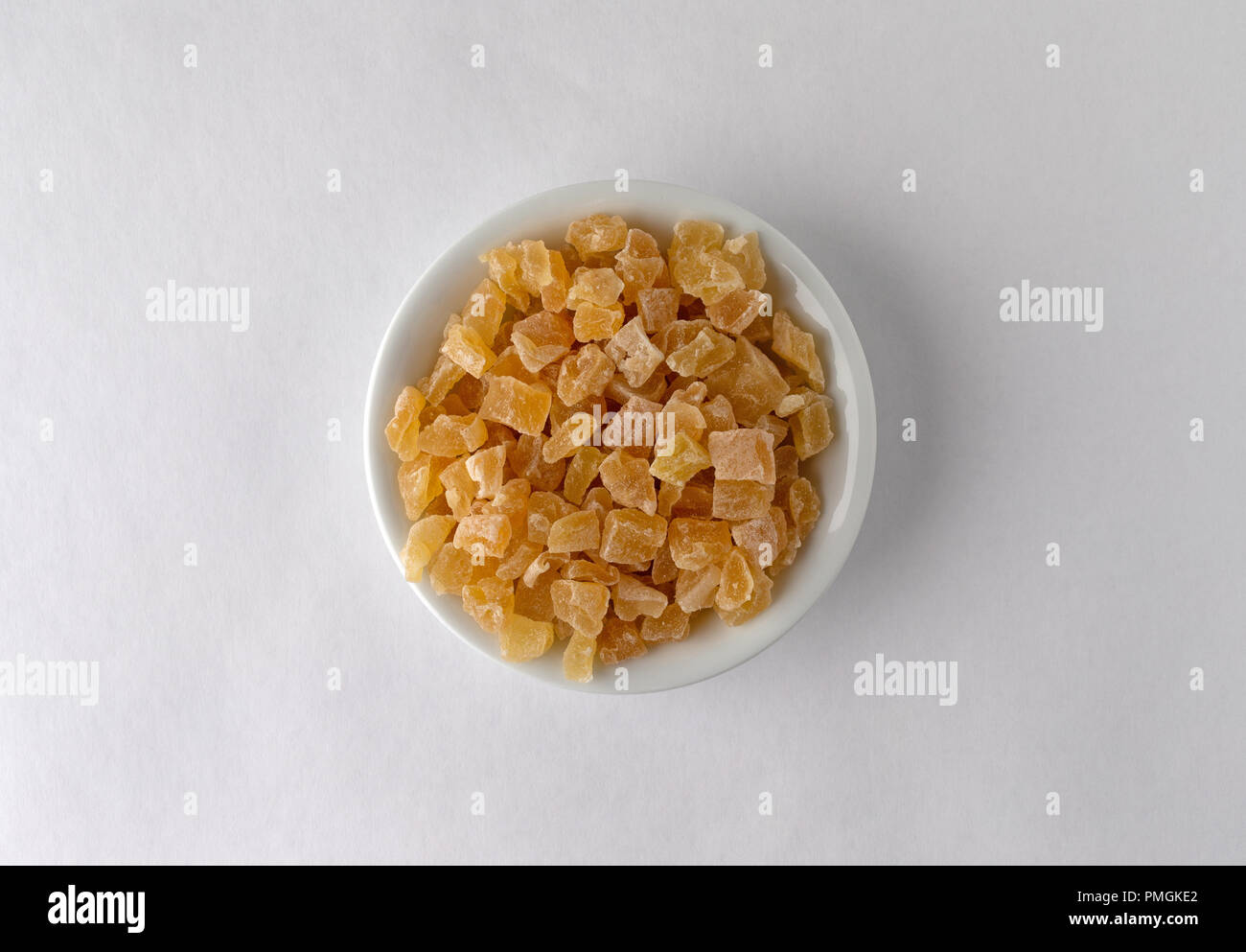 Vista superiore del cubettato di secche Pesche in una ciotola su uno sfondo bianco illuminato con luce della finestra. Foto Stock