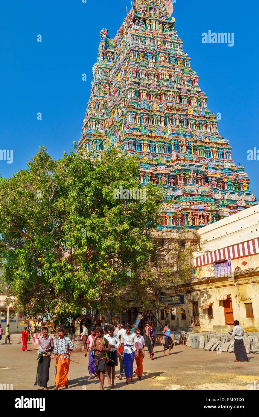 Tempio di Madurai MADURAI TAMIL NADU INDIA UNA TORRE COMPOSTA PRINCIPALMENTE DI colonne colorate e un gruppo di pellegrini maschio Foto Stock