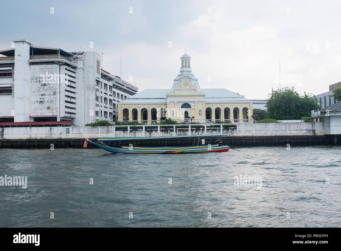 Tradizionale barca dalla coda lunga passa la scuola Rajini sul Fiume Chao Phraya a Bangkok, in Thailandia Foto Stock