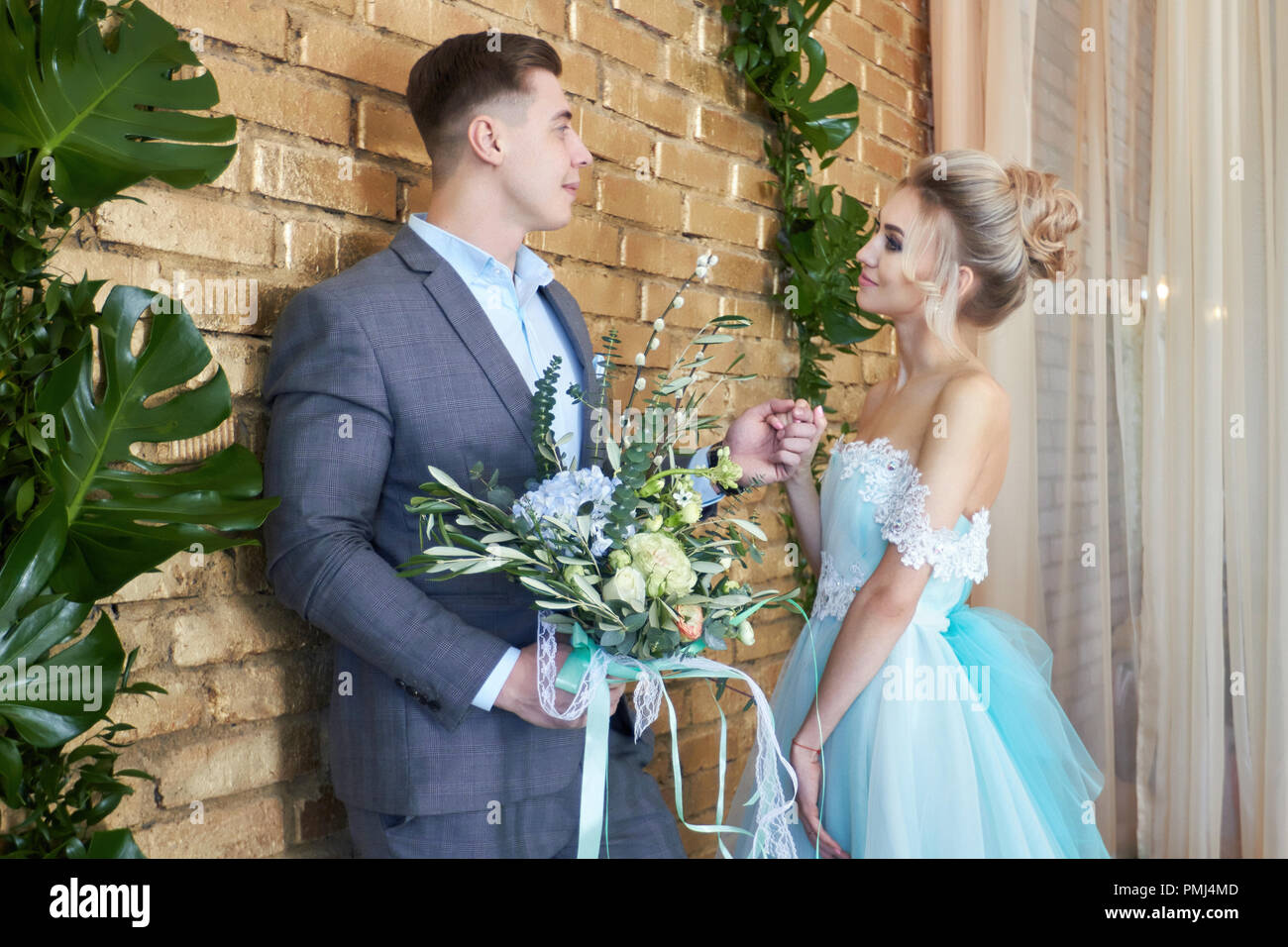 Gli sposi, amare giovane prima del matrimonio. L uomo e la donna amarsi. La  sposa in abito color turchese e lo sposo in una tuta blu. Abbiamo Foto  stock - Alamy